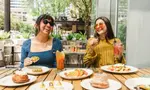 Two people enjoying brunch at Caroline Restaurant in Austin, Texas