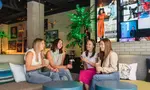 Four people enjoying drinks inside the Moxy Hotel.